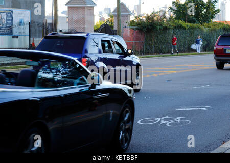 Auto in velocità su una strada condivisa con i ciclisti come indicato con un simbolo di sharrows Foto Stock
