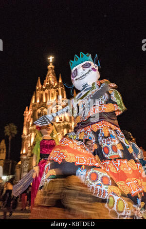 Carta gigante-mache marionette chiamato danza mojigangas passato la parroquia chiesa durante la settimana di festa del patrono san michele settembre 26, 2017 in San Miguel De Allende, Messico. Foto Stock