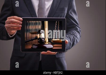 Immagine composita dell'uomo utilizzando tablet pc. il diritto e la giustizia concetto Foto Stock