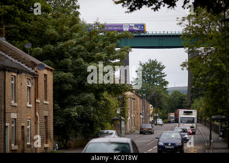 A57 sotto il viadotto Dinting (archi) Glossopdale, Derbyshire, porta il Glossop linee ferroviarie pendolari . Ferrovie Nord classe 323 direzione Foto Stock