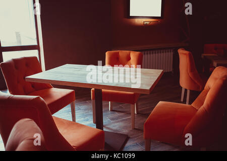 Bellissimo Ristorante interno con tavoli in legno e poltrone Foto Stock