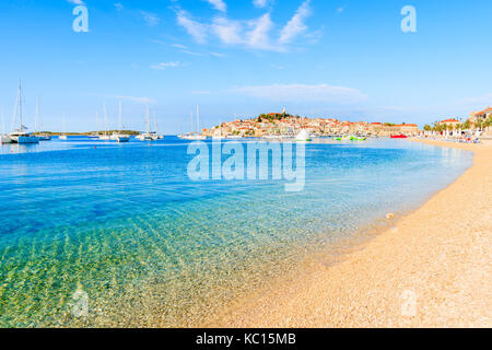 Spiaggia con mare cristallino in acqua Primošten Città al mattino presto, Dalmazia, Croazia Foto Stock