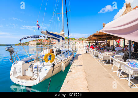 Porto di Milna, Croazia - Sep 12, 2017: barca a vela ormeggio nel porto di Milna e turisti che si godono le bevande nelle zone costiere cafe, isola di Brac, Croazia. Foto Stock