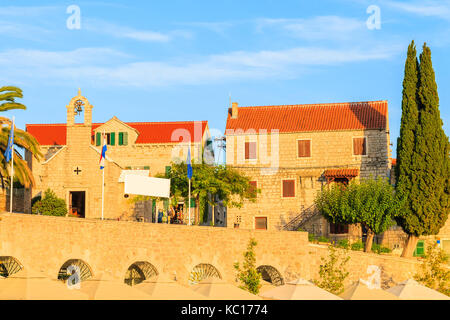 Vista del tipico vecchio case e chiesa in bol porto al tramonto del tempo, isola di Brac, Croazia Foto Stock