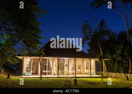 Accogliente casa tropicale balinese con luci di notte. Foto Stock