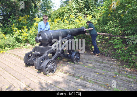 I visitatori di ispezionare un cannone britannico a Redoubt dalla guerra di 1812 lungo le cascate del Niagara Parkway in Ontario, Canada Foto Stock