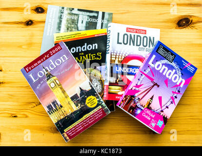 Pila di Londra Travel guide su una tavola di legno Foto Stock