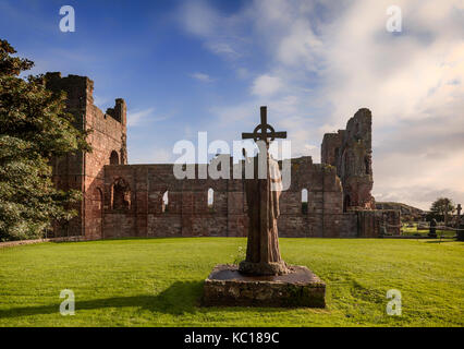 St Cuthbert della statua accanto alle rovine della chiesa, costruita intorno al 1150, sul luogo in cui il suo corpo fu sepolto a Isola Santa, Northumberland, Inghilterra Foto Stock