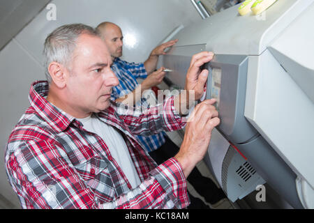 I tecnici controllare una grande le stampanti a getto di inchiostro Foto Stock