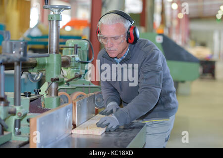 Artigiano con la protezione del lavoro e di protezione per le orecchie Foto Stock