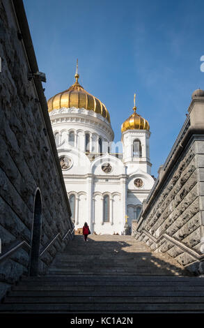 Donna salire a piedi a gradini che portano alla suggestiva facciata esterna della Cattedrale di Cristo Salvatore a Mosca, Russia Foto Stock