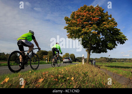 I ciclisti che viaggiano su una strada di campagna in autunno a Mülheim an der Ruhr, Germania Foto Stock
