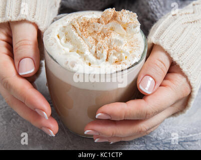 Donna mani con caffè latte su un tavolo Foto Stock