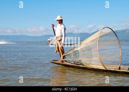 Lago Inle, myanmar - 15 novembre 2014. intha fisherman visualizzazione metodo di canottaggio e coniche netti per la cattura del pesce. Foto Stock