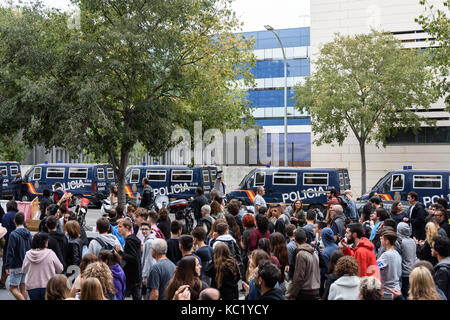 Barcellona, Spagna. 1 Ottobre 2017. Persone che passano davanti a una fila di pulmini di polizia a Barcellona. Credit: Daniel Baker/Alamy Live News Foto Stock