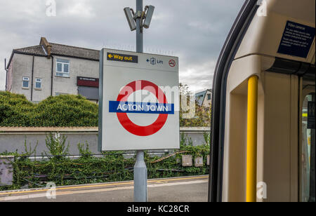 La metropolitana di Londra di Acton Town tube station segno sulla piattaforma vuota, preso dall'interno del tubo in treno, con nessuno attorno a. London, W3, Inghilterra, Regno Unito. Foto Stock