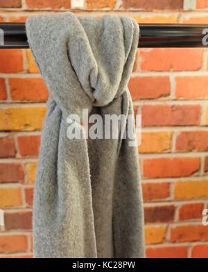 Bella sciarpa grigio legata da appendere l'uso di barre di usura intorno al collo per il calore e la moda. Foto Stock