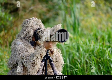 Il camuffamento Wildlife Photographer in Ghillie Suit lavora nel selvaggio Foto Stock