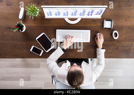 Giovane imprenditrice guardando il Calendario sul computer in ufficio Foto Stock