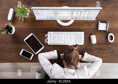 Giovane imprenditrice di dormire sulla scrivania al lavoro Foto Stock