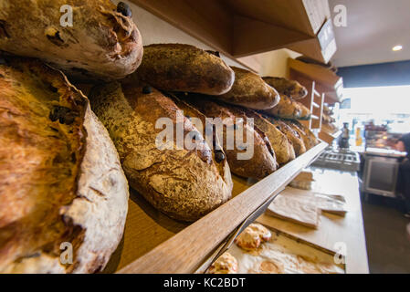 Pasta acida fresca Pane impilati pronti per la vendita in un Sydney, Australia panificio Foto Stock