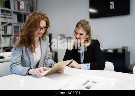 Giovani architetti attraente con tavoletta digitale in ufficio Foto Stock