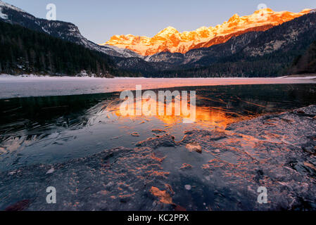 Sunrise tovels lago in una fredda giornata invernale, parco naturale Adamello Brenta, Val di Non, in trentino alto adige, italia. Foto Stock