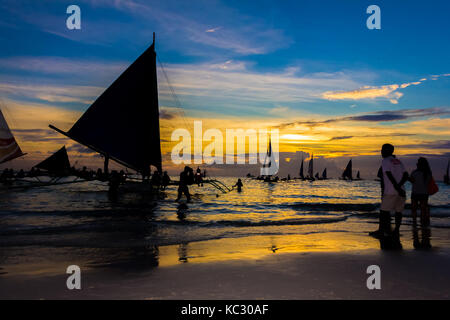 Il Boracay, Filippine - 16 SET 2015: persone nelle barche a vela rilassante sul mare al tramonto, Boracay, Filippine Foto Stock