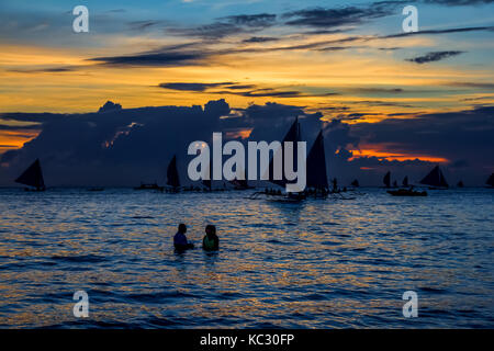 Il Boracay, Filippine - 16 SET 2015: drammatico tramonto con barca a vela nel paese tropicale, nuvole. Ampio angolo. sagome di barche, il disco solare. phili Foto Stock