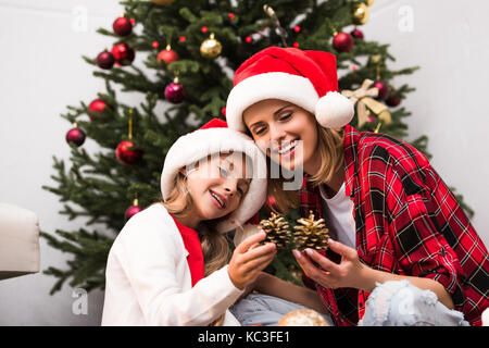 Madre e figlia decorare albero di natale Foto Stock