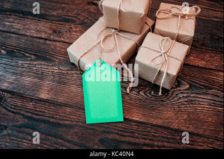 Mockup scatole per doni di carta kraft e dono tag su un sfondo di legno Foto Stock