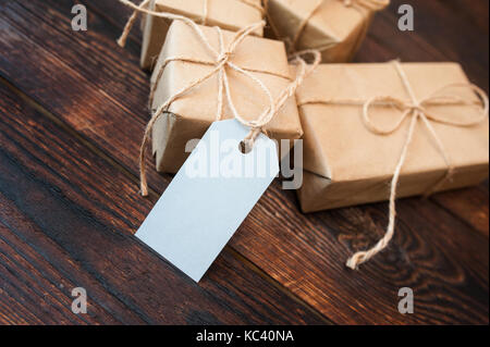Mockup scatole per doni di carta kraft e dono tag su un sfondo di legno Foto Stock