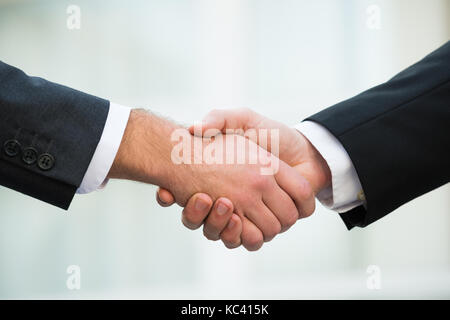 Immagine ritagliata di uomini di affari si stringono la mano all'aperto Foto Stock