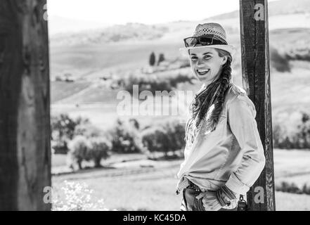 Alla scoperta di magiche vedute della Toscana. ritratto di avventura sorridente donna escursionista in hat escursioni in Toscana Foto Stock