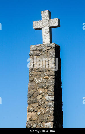 Croce, simbolo cristiano, su una colonna di pietra contro il cielo blu, Portogallo Foto Stock