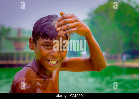 Delhi, India - 16 settembre 2017: ritratto di un massimo di unidentified sorridente ragazzo indiano, toccando la sua testa con la mano e guardando la telecamera, a Delhi Foto Stock