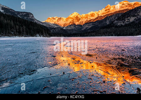 Sunrise tovels lago in una fredda giornata invernale, parco naturale Adamello Brenta, Val di Non, in trentino alto adige, italia. Foto Stock