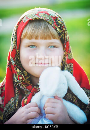 Una bella bambina in una bellissima sciarpa Foto Stock