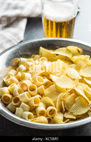 Croccanti patatine e gli anelli nel recipiente. Salate potato chips. Foto Stock