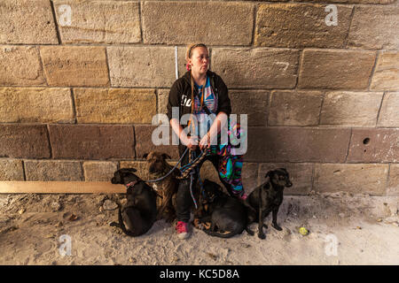 La donna a camminare con i suoi quattro cani, in piedi sotto un ponte, Praga, Repubblica Ceca Foto Stock