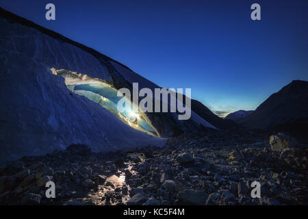 Explorer all'interno di una caverna di ghiaccio durante una spedizione di fotografia in Ghiacciaio Athabasca Foto Stock
