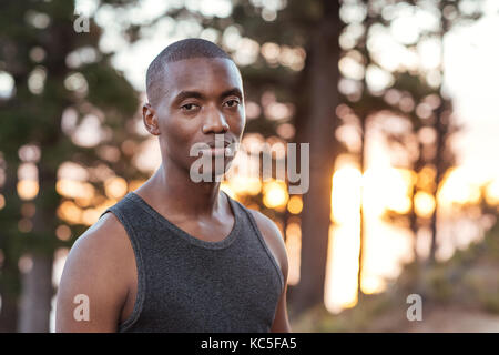 Focalizzato l'uomo africano in piedi su un sentiero mentre jogging Foto Stock