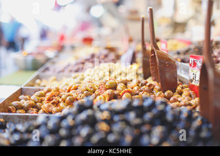 Olive pila nel mercato degli agricoltori , verde e nero fresco di olive in salamoia con un cucchiaio DOF luce diurna Foto Stock