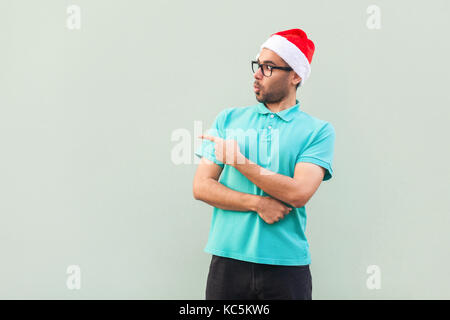 Wow! Uomo bello con la barba in shoked. rivolto lontano mentre in piedi isolato su sfondo grigio. studio shot Foto Stock