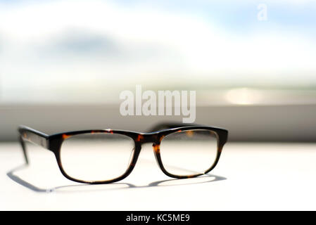 Coppia di marrone tartaruga occhiali su un bianco davanzale soleggiato Foto Stock