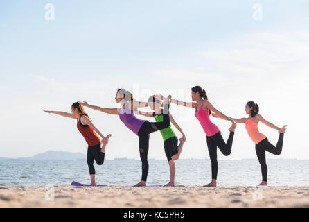 Yoga classe a mare spiaggia in sera ,gruppo di persone che fanno il signore della danza pone con vongole emozione relax in spiaggia,meditazione pongono,il benessere e la salute Foto Stock