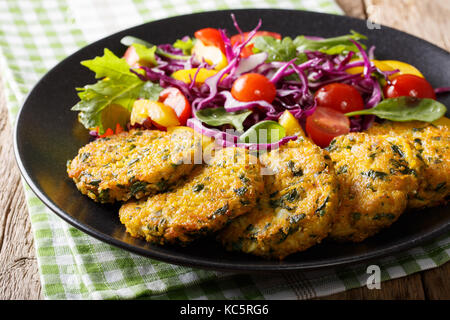 Deliziosi hamburger di quinoa, carote e spinaci e verdure fresche close-up su una piastra orizzontale. Foto Stock