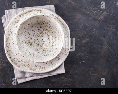 Bianco piastra artigianali su nero ardesia tabella Foto Stock