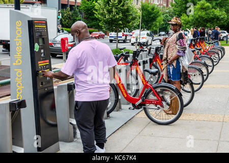 Washington DC,Dupont Circle,capitale bikeshare,sistema di condivisione bicicletta,bicicletta,noleggio stazione,uomo nero uomo maschio,donna donna donna donna donna,DC170527116 Foto Stock