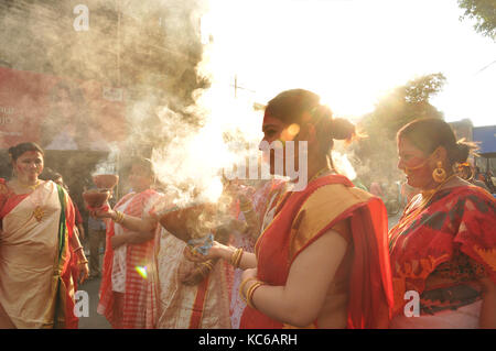 Le donne indiane di eseguire la danza con dhunachi durante la processione di immersione della dea durga idolo Foto Stock